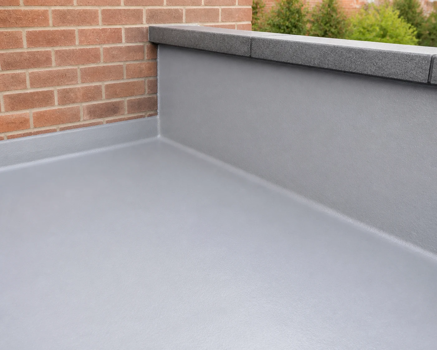 Seamless liquid coating protecting a flat roof upstand.
